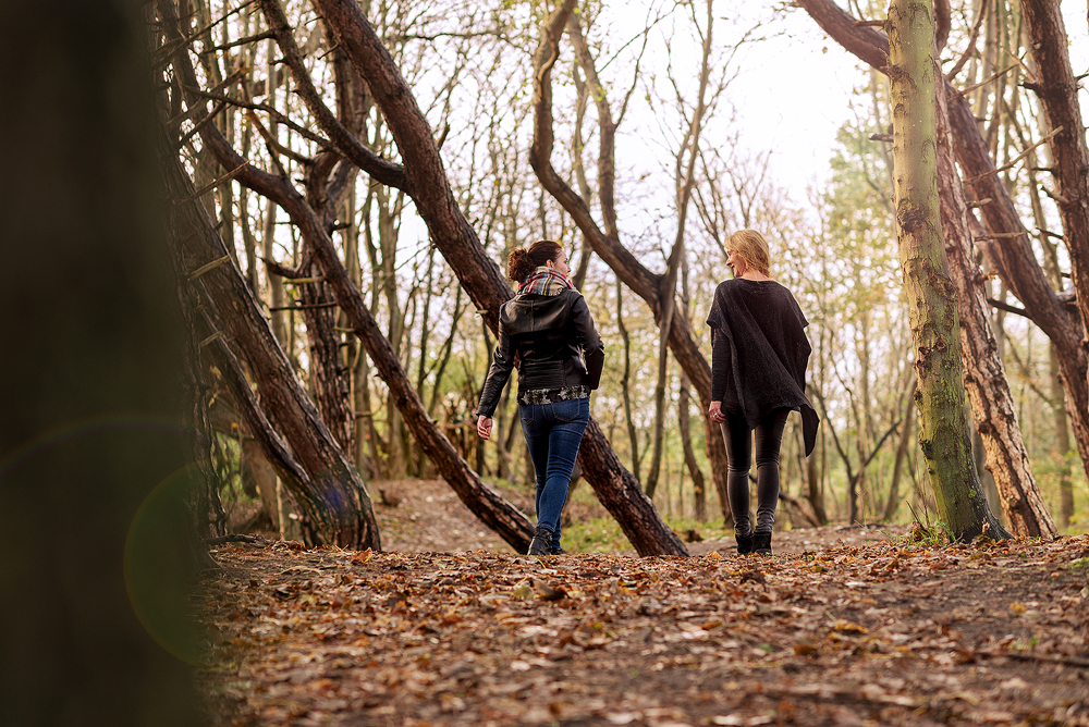Twee vrouwen wandelen in een herfstbos